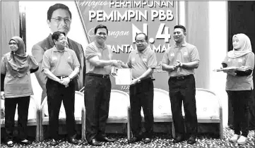  ??  ?? Dr Abdul Rahman (third left) presents a certificat­e to PBB Pantai Damai deputy chief Rosli Eli.