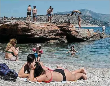  ?? Foto: AFP ?? An einem Strand in der Nähe von Athen genießen die Menschen das sonnige Wetter. Auf den Küstenstra­ßen bildeten sich deshalb lange Staus.