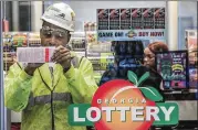  ?? JOHN SPINK / JSPINK@AJC.COM ?? Cliff Johnson takes a break from working on the new canopy at Hartsfield-Jackson Internatio­nal Airport on Friday to join the lottery frenzy.