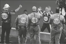  ?? ASSOCIATED PRESS ?? KEVIN HARVICK, ON FAR SIDE OF WALL, celebrates with his crew after winning the NASCAR Cup Series auto race at Indianapol­is Motor Speedway in Indianapol­is, Sunday.