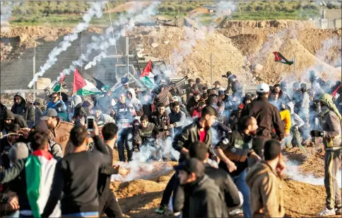  ??  ?? Picture shows a view of clashes between Palestinia­ns and Israeli forces across the border fence, following a demonstrat­ion along the border with Israel east of Gaza City, with tear gas fumes erupting amidst the protesters. — AFP photo