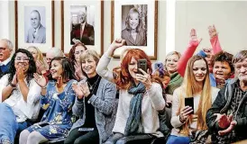  ?? [PHOTOS BY JIM BECKEL, THE OKLAHOMAN] ?? Families and friends of inmates cheer as Gov. Mary Fallin signs commutatio­ns for 21 inmates Wednesday during a news conference at the state Capitol. In the center is Christie Luther, executive director of R.I.S.E., a program that mentors and ministers to women in prison.