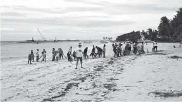  ?? JAYPEE ?? Volunteers clean the shores of Santa Fe town on Bantayan Island yesterday morning.