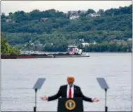  ?? JOHN MINCHILLO — THE ASSOCIATED PRESS FILE ?? In this file photo, a coal barge is positioned as a backdrop behind President Donald Trump as he speaks during a rally at the Rivertowne Marina in Cincinnati. President Donald Trump personally promised to activate emergency legal authoritie­s to keep...