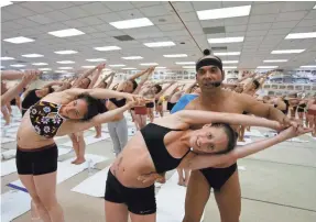  ?? DAN MACMEDAN/USA TODAY ?? Jeanne Orzano is adjusted by Bikram Choudhury during a class in 2006.