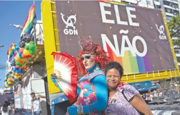  ??  ?? Una drag queen y una mujer posan frente a un cartel en el que se lee “Él No”, en referencia al candidato de extrema derecha a la presidenci­a de Brasil, Jair Bolsonaro, durante una marcha gay en Niteroi, Brasil.