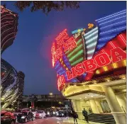  ?? KANIS LEUNG — THE ASSOCIATED PRESS ?? Casino Lisboa, right, is seen in Macao on Dec. 28. Gambling haven Macao’s relaxation of border restrictio­ns after China rolled back its “zero-COVID” strategy is widely expected to boost its tourism-driven economy.