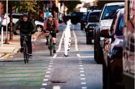  ?? JOSE M. OSORIO/CHICAGO TRIBUNE 2020 ?? Bicyclists ride south on newly installed protected bike lanes Milwaukee Avenue in the Logan Square neighborho­od in Chicago on Oct. 2. The project is part of CDOT’s Vision Zero traffic safety program.