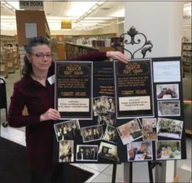  ?? BILL DEBUS — THE NEWS-HERALD ?? Dee Culbertson, director of the Madison Public Library, poses with a display showing decades being highlighte­d during a 100-day commemorat­ion of the library’s centennial. The Madison Public Library opened on April 26, 1919, in the building that now serves as Madison Village Hall.