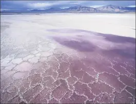  ?? RICK BOWMER — THE ASSOCIATED PRESS ?? Pink water washes over a salt crust in May along a receding edge of the Great Salt Lake. The lake has been shrinking for years.