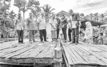  ??  ?? Sharifah Zarah (third right) visits the damaged home of aid recipient in the Connecting-the-Unconnecte­d (CTU) programme at Kampung Bukit Tandak in Rantau Panjang. — Bernama photo