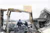  ?? PHOTO: REUTERS ?? Royal Canadian Mounted Police officers investigat­e the remains of a lobster pound that was destroyed by a fire, in Middle West Pubnico, Nova Scotia, yesterday.