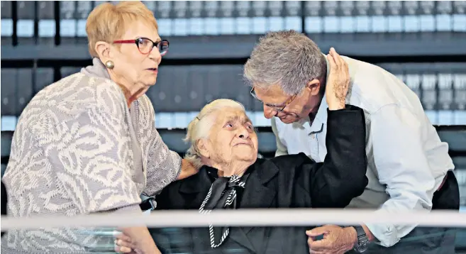  ??  ?? Below: Melpomeni Dina is reunited with Yossi Mor and his sister Sarah Yanai at the Hall of Names at the Yad Vashem Holocaust Memorial museum in Jerusalem