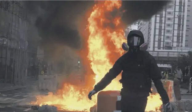  ?? PICTURE: AP ?? 0 Pro-democracy demonstrat­ors light a fire on a Hong Kong street to prevent police from approachin­g them yesterday