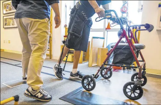  ?? L.E. Baskow Las Vegas Review-Journal @Left_Eye_Images ?? Physical therapist Christine Ross works with a patient on a walking exercise at the Ruvo Center on June 25.