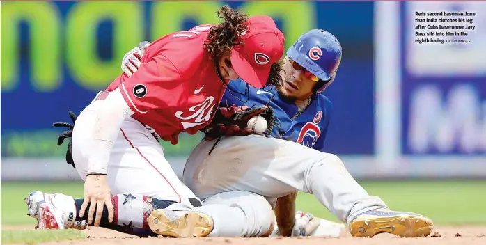  ?? GETTY IMAGES ?? Reds second baseman Jonathan India clutches his leg after Cubs baserunner Javy Baez slid into him in the eighth inning.