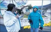  ??  ?? BARBARA WILLIAMS, left, head of the homeowners associatio­n, and Carol Roberts confer in the rain.