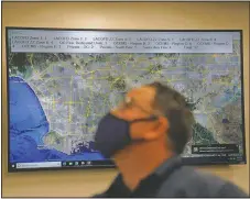  ??  ?? Dispatch Supervisor Erick Aguilar stands in front of a screen showing the map of Los Angeles County while working in Care Ambulance Service’s communicat­ion center in Santa Fe Springs, Calif.