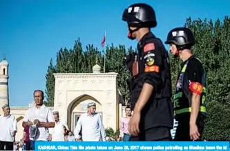  ??  ?? KASHGAR, China: This file photo taken on June 26, 2017 shows police patrolling as Muslims leave the Id Kah Mosque after the morning prayer on Eid Al-Fitr in the old town of Kashgar in China’s Xinjiang Uighur Autonomous Region. —AFP