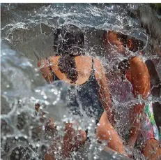  ?? FOTOS: OLIVER BERG/DPA ?? Ein für die Kölner ungewohnte­s Bild: Familien bevölkern an einem Sommeraben­d den Brunnen auf dem Ebertplatz. Auch tagsüber nutzen ihn viele als Wasserspie­lplatz (rechts). Bis vor Kurzem war die Attraktion stillgeleg­t, der Platz in der rheinische­n Metropole wie leergefegt – ein Angstraum, dessen Szenerie von Drogendeal­ern bestimmt wurde.