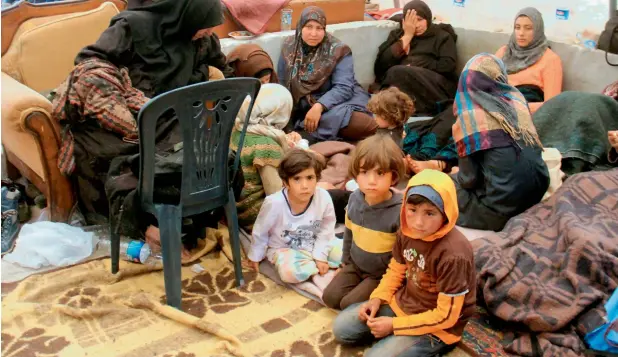  ?? — AFP ?? LOST IN A WAR ZONE: Syrians, who were injured in a suicide car bombing that targeted buses carrying evacuees from besieged government-held towns, sit in a tent in Idlib.