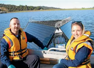  ?? PHOTO: SIMON SMITH/FAIRFAX NZ ?? Watercare staff Matt Hubrick, left, and Amy Holliday inspect one of the solar-panel powered buoys.
