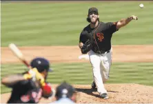  ?? Tim Warner / Getty Images ?? Madison Bumgarner pitches in the second inning against Cleveland. He went four innings, giving up two unearned runs.