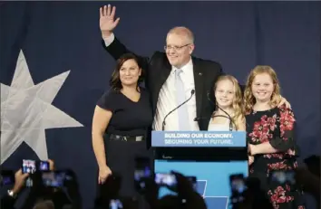  ?? Rick Rycroft/Associated Press ?? Australian Prime Minister Scott Morrison waves to party supporters along with his wife, Jenny, and daughters Lily and Abbey, after his opponent concedes in the federal election Sunday in Sydney.