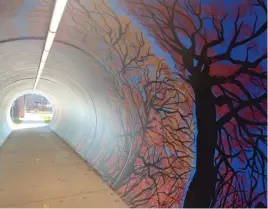  ?? ROBERT HERGUTH/SUN-TIMES PHOTOS ?? The colors of the foliage and sky show the changing of the seasons in artist Juan De La Mora’s mural inside a pedestrian tunnel in Glen Ellyn.