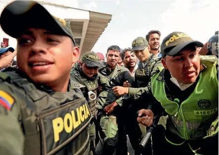  ?? AP ?? Colombian police escort a Venezuelan soldier who surrendere­d at the Simon Bolivar internatio­nal bridge, where Venezuelan­s tried to deliver humanitari­an aid despite objections from President Nicolas Maduro.