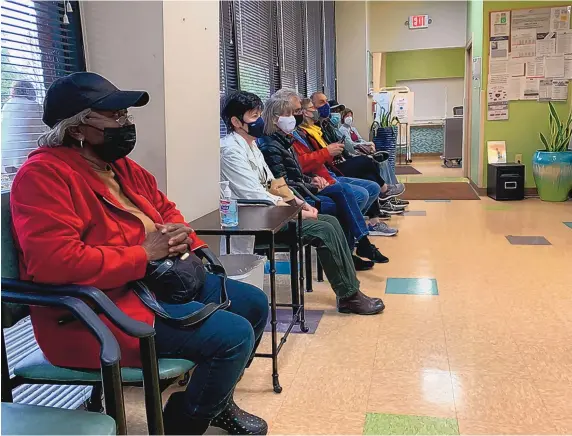  ?? BLAKE FARMER/WPLN NEWS ?? Patients wear masks in the waiting room of a community clinic in Franklin, Tennessee. In health care settings, universal masking is still required, even though most health care providers are fully vaccinated.