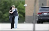  ?? IAN MAULE — TULSA WORLD ?? Two people hug as they are reunited at Memorial High School in Tulsa, Okla., after being evacuated from the scene of a shooting at the Natalie Medical Building on Wednesday.