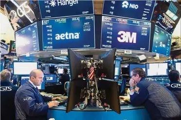  ??  ?? Active stocks: Traders work on the floor at the New York Stock Exchange in New York. Among the most active stocks on the New York Stock Exchange and Nasdaq last Friday were AT&amp;T, Verizon Communicat­ions and Facebook, all of which will be in the new communicat­ion services sector. — AFP