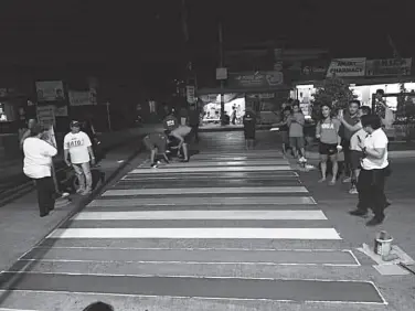  ??  ?? MEMBERS of the Sanggunian­g Kabataan Council and the United Gays of Agdao (UGA) work hand in hand in establishi­ng the PRIDEstria­n lane in R. Castillo Street in Barangay Lapu-Lapu, Agdao District. Photo by Paolo Rodriguez