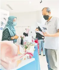  ?? ?? TAKLIMAT: Sesi penerangan berkaitan alat bantu dengar di ruang pameran karnival.