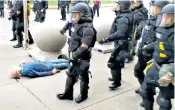  ??  ?? A 75-year-old lies bleeding after being pushed over by Buffalo police, and below, fraternity members march on Brooklyn Bridge