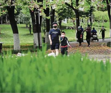  ?? Foto: AFP ?? Vater und Sohn in einem Park in Wuhan. Gestern hat Peking lediglich 31 Neuinfekti­onen für das gesamte Land vermeldet, darunter 30 „importiert­e Fälle“– also eingefloge­ne Personen aus dem Ausland.