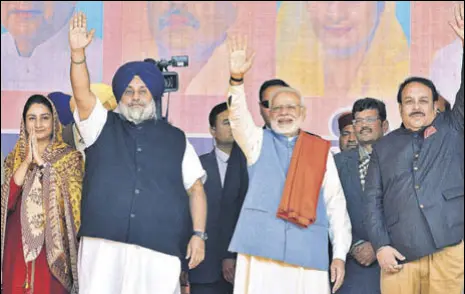  ?? SAMEER SEHGAL/HT ?? Prime Minister Narendra Modi flanked by Punjab BJP chief Shwait Malik and SAD president Sukhbir Singh Badal at the Dhanwad Rally in Gurdaspur on Thursday. Union minister Harsimrat Kaur is also seen in the picture. (Right) A BJP worker at the rally.