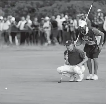  ?? PETER MORRISON/AP PHOTO ?? Jordan Spieth and caddie Michale Greller line up a putt on the ninth hole during the third round of the British Open on Saturday in Carnoustie, Scotland. Spieth, the reigning champion, shot a 6-under-par 65 to move into a three-way tie for the lead heading into today’s final round.