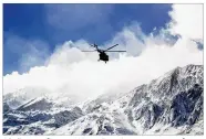  ?? ALI KHODAEI / TASNIM NEWS AGENCY VIA AP ?? A helicopter flies over Mount Dena in a remote part of southern Iran on Monday in search of wreckage from a plane that crashed a day earlier. All 65 people on board were killed, officials said.