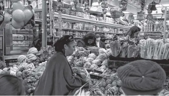  ?? KEVIN COOMBS ■ REUTERS ?? Customers shop at a supermarke­t in London in December.