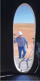  ??  ?? Avangrid Developmen­t Director Mark Stacy climbs stairs to the entrance door at the base of a wind turbine tower at El Cabo Wind Farm.