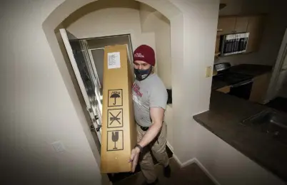  ?? Photos by David Zalubowski, The Associated Press ?? Team Rubicon volunteer Nicholas Duchnowski of Broomfield moves belongings on Wednesday into a Thornton apartment that will be the new home of a family of Afghan refugees.