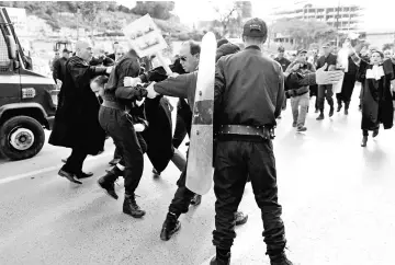  ??  ?? Police attempt to disperse lawyers trying to force their way to the constituti­onal council during a protest to denounce an offer by Bouteflika to run in elections next month but not to serve a full term if re-elected, in Algiers, Algeria. — Reuters photo