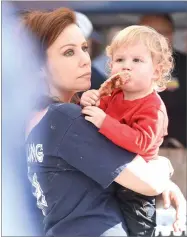  ??  ?? Left: Ayden Rodriguez, 1, right, enjoys a rib while listening to live music with his grandmothe­r Christy Mekvixiang Saturday, Nov. 3, at the annual Rib Cook-off downtown Lindsay. Right: Rafael Medina of Mittman-denni Farming, Inc. flips a rack of ribs Saturday, Nov. 3, at the annual Rib Cook-off in downtown Lindsay. His team participat­ed for the first time in the event.