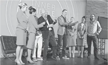  ?? PETER BARRERAS, AP IMAGES FOR VIRGIN MOBILE ?? Founder Sir Richard Branson, center, and Virgin Mobile USA CEO Dow Draper pop champagne alongside flight attendants during the Virgin Mobile Inner Circle launch event in June.