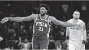  ??  ?? Philadelph­ia 76ers’ Joel Embiid celebrates after scoring three points as Washington Wizards’ Marcin Gortat looks on. Embiid sat out the 76ers’ game Wednesday night against Miami because of soreness in his right ankle.