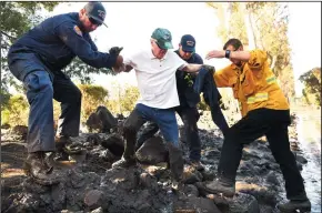  ?? WALLY SKALIJ/LOS ANGELES TIMES ?? Firefighte­rs from left, Mark Todd, John Cecena and Jeff Shea, help Birmawood Country Club resident Terry Connery escape his home in Montecito on Wednesday.