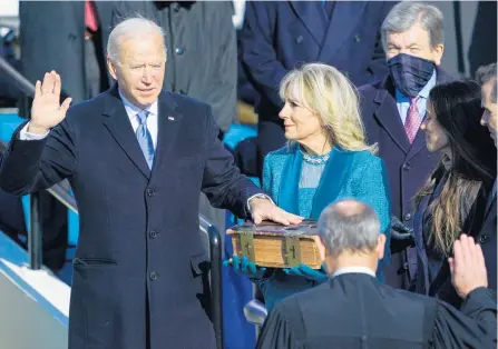  ?? CHANG W. LEE/THE NEW YORK TIMES ?? Chief Justice John Roberts swears in Joe Biden as the 46th President of the United States, as his wife Jill Biden holds a Bible at the Capitol in Washington on Wednesday.