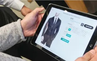  ?? BEBETO MATTHEWS/AP ?? Bonobos guide Reynaldo Sanchez inputs clothing informatio­n into the store’s customer website for customer J.P. Grant, after Grant shopped for clothing at the brand’s Guideshop, in New York. More shoppers are looking to social media or curated...